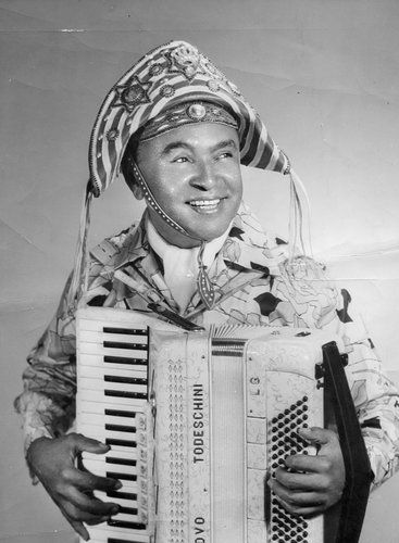 an old black and white photo of a man holding an accordion