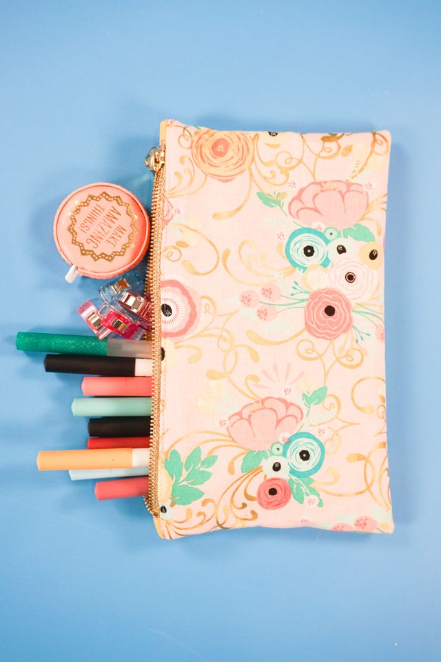 the pencils are lined up in front of the zippered pouch on the blue surface