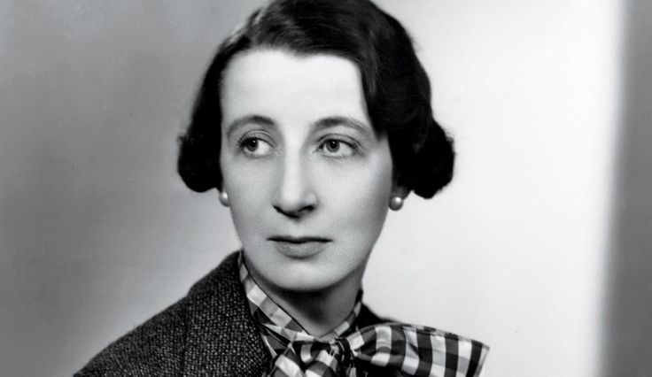 an old black and white photo of a woman with a bow tie on her neck