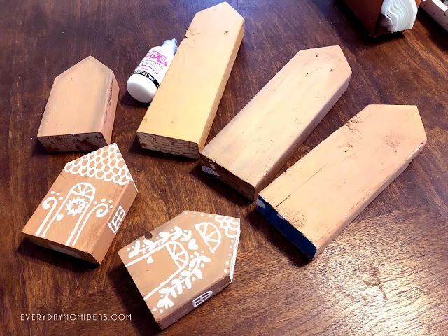 several pieces of wood with white designs on them sitting on a table next to some glue