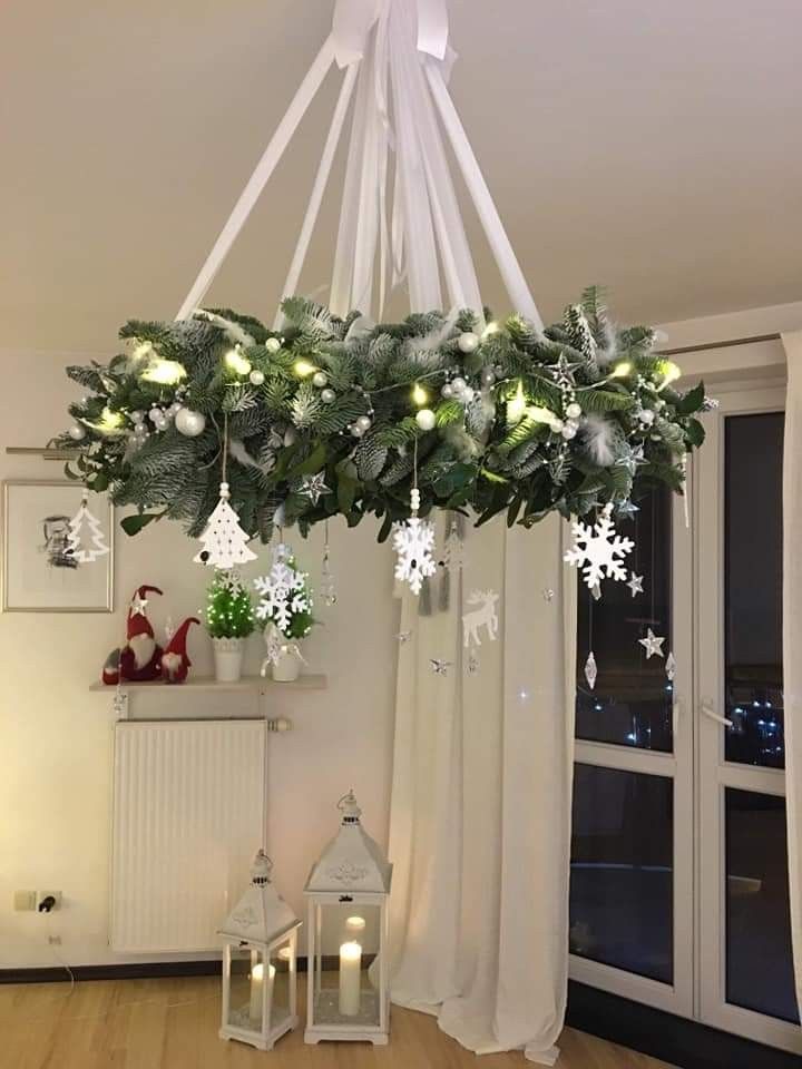 a chandelier hanging from the ceiling with christmas decorations