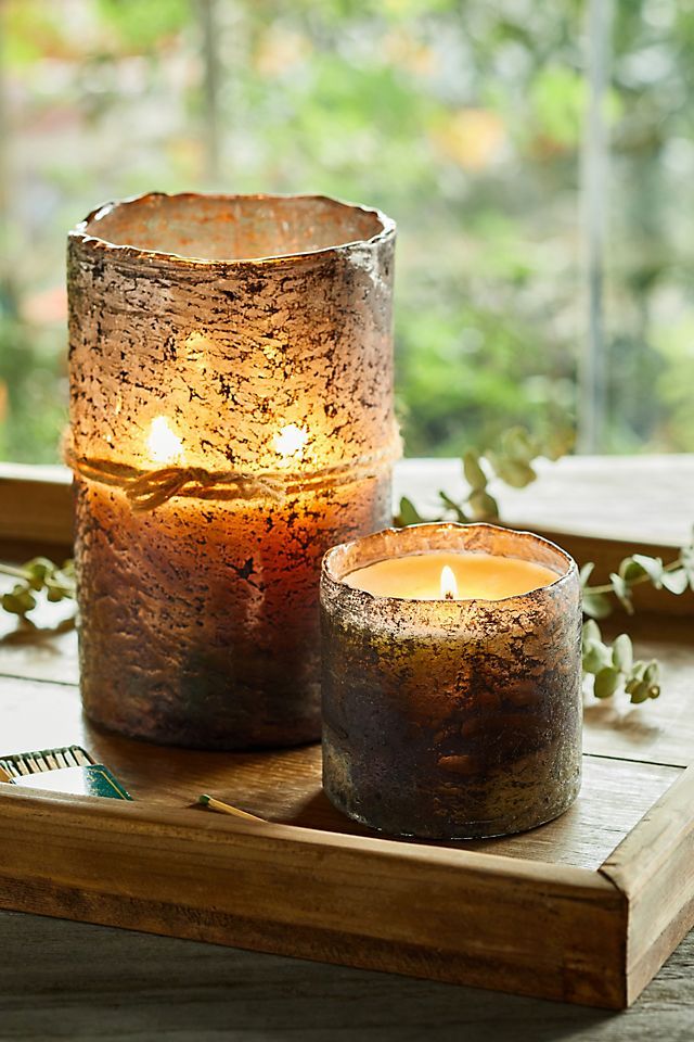 two candles sitting on top of a wooden tray