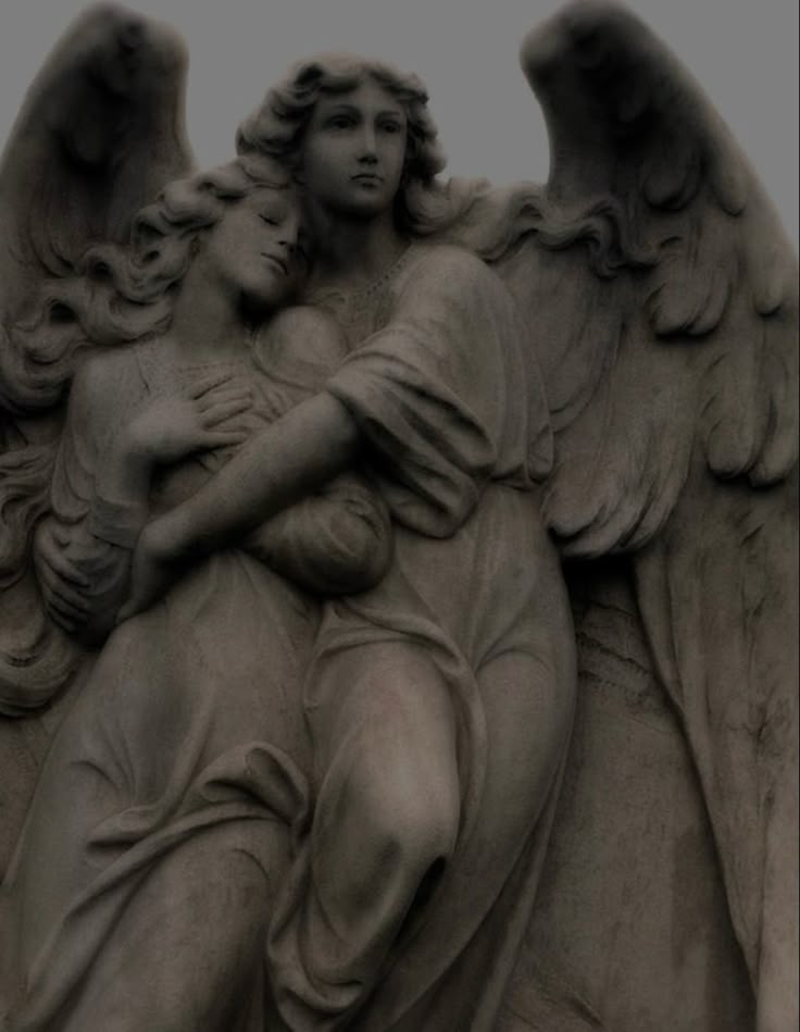 an angel statue holding a child in its arms