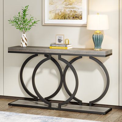 a modern console table with two circular metal legs and a marble top, in a living room