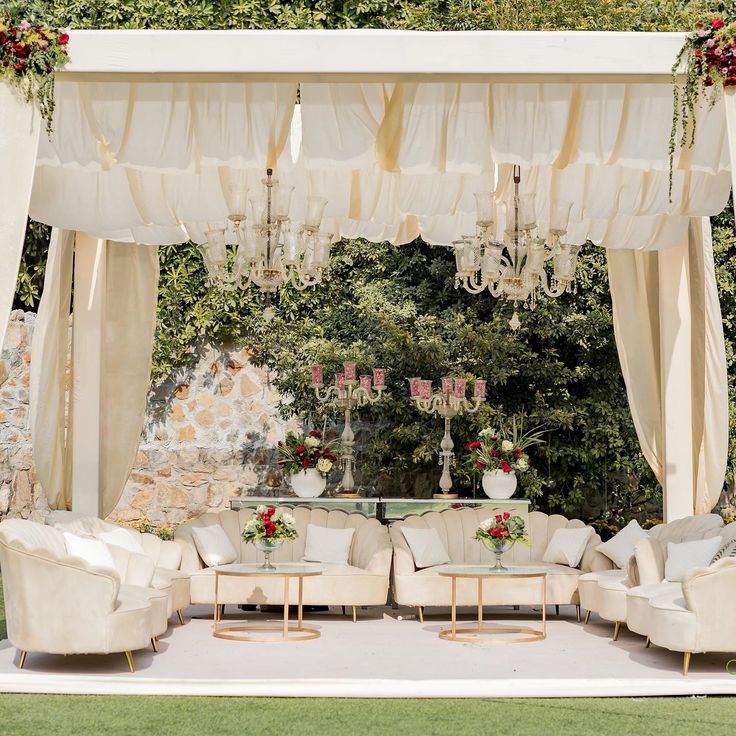 an outdoor wedding setup with couches and chandeliers