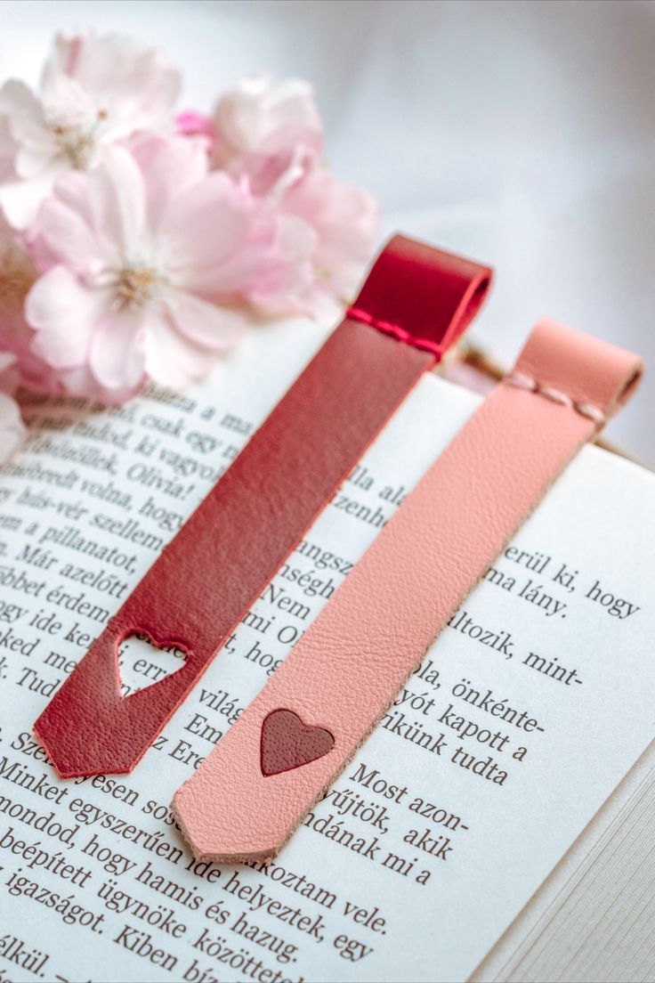 a bookmark with a heart on it next to flowers