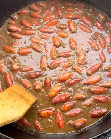 hot dogs are being cooked in a pan on the stove