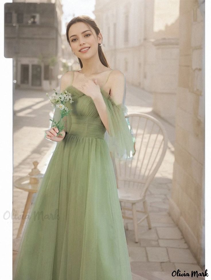 a woman in a green dress posing for the camera