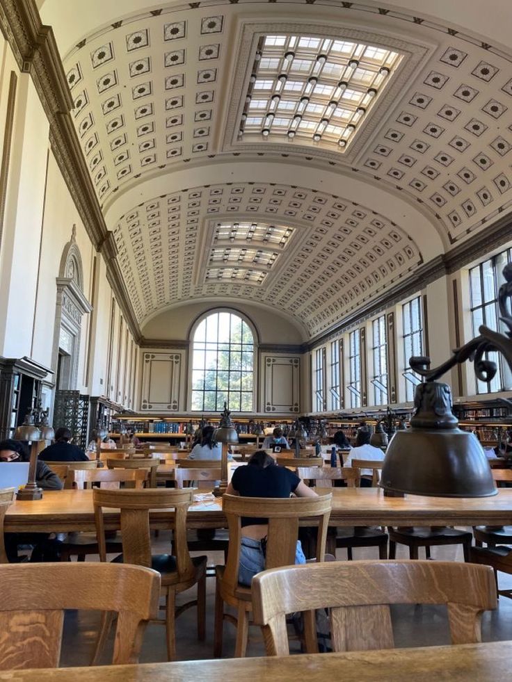 people are sitting at tables in the library