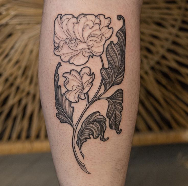 a black and white flower tattoo on the leg