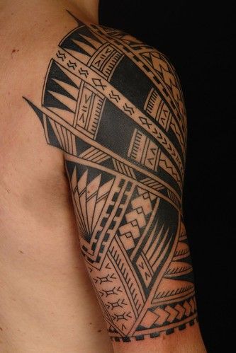 a man with a black and grey tattoo on his arm