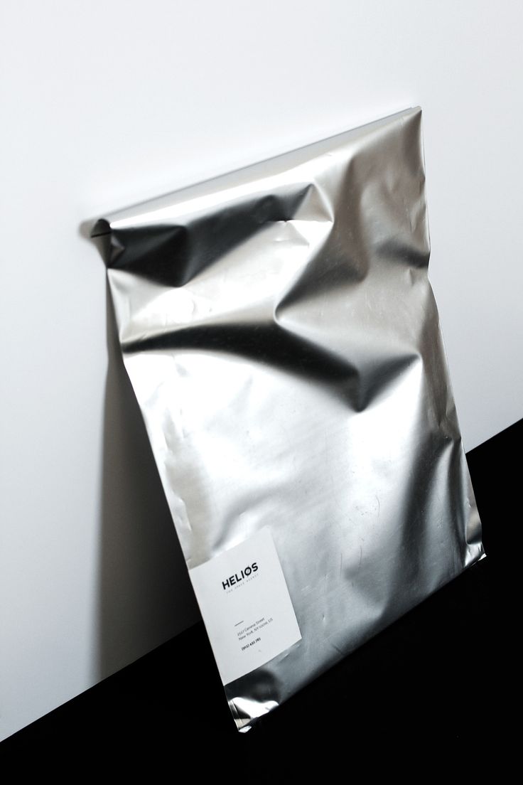 a silver foil bag sitting on top of a black table next to a white wall