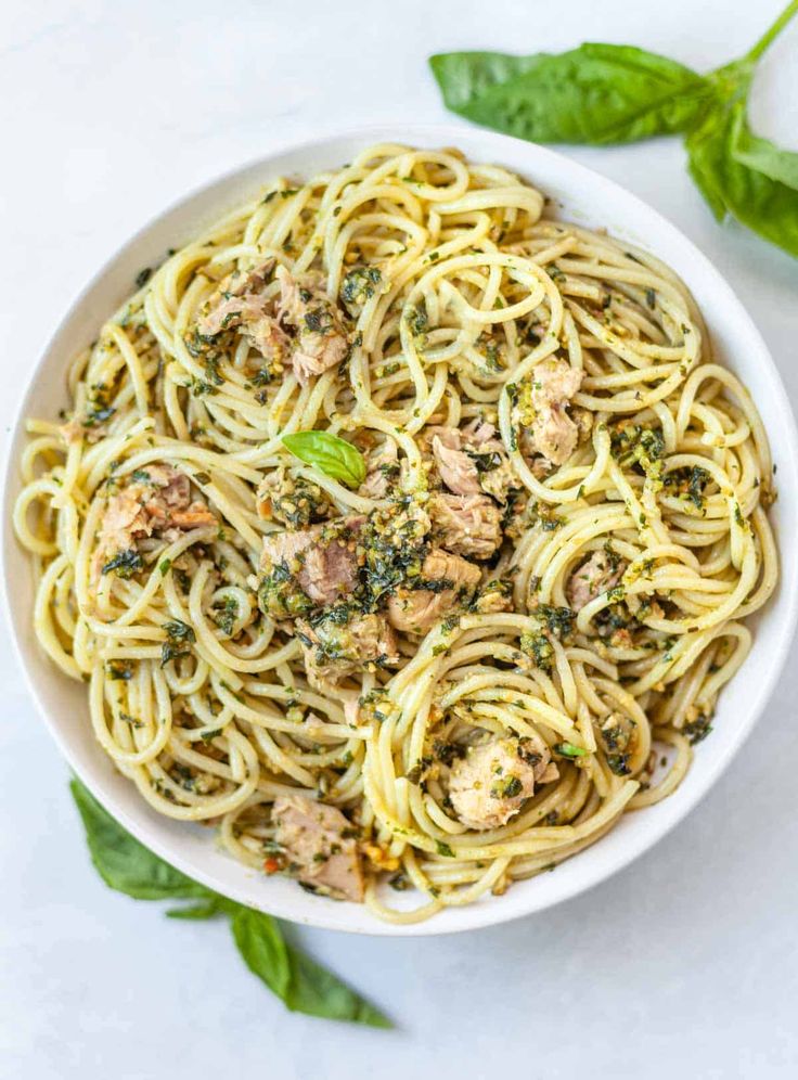 a white bowl filled with pasta and meat