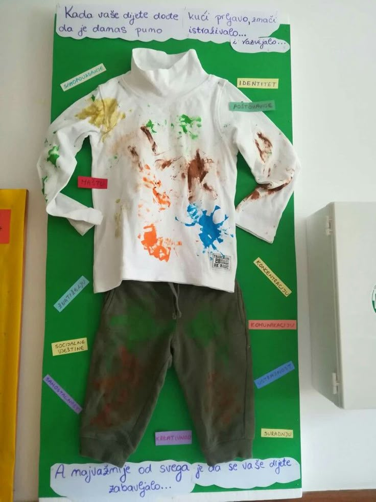 a child's shirt and pants made out of paper with paint splattered on them