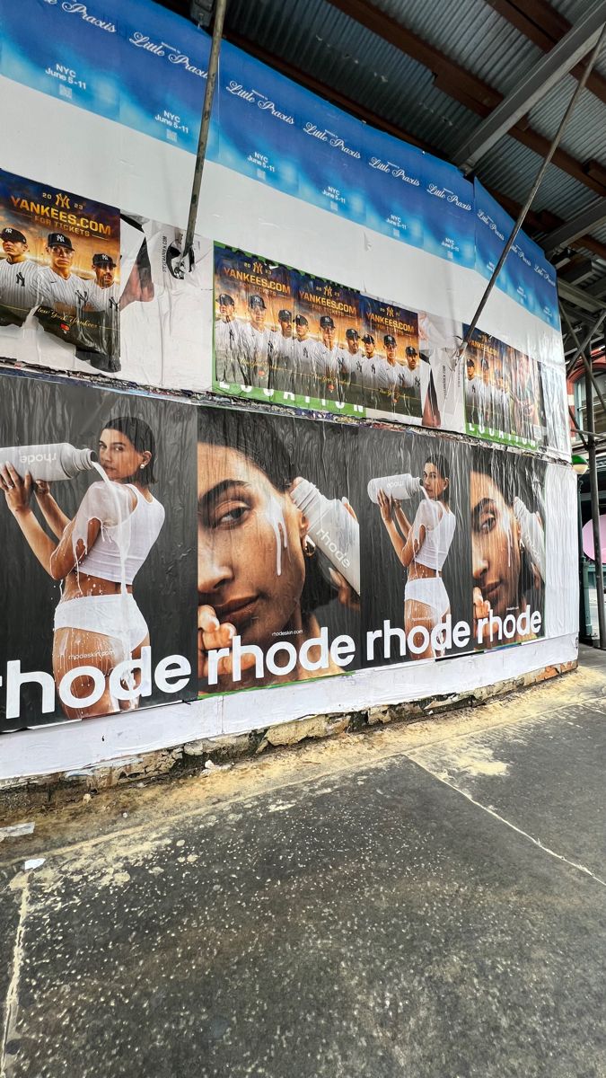 a large advertisement on the side of a building in front of a wall with images of women