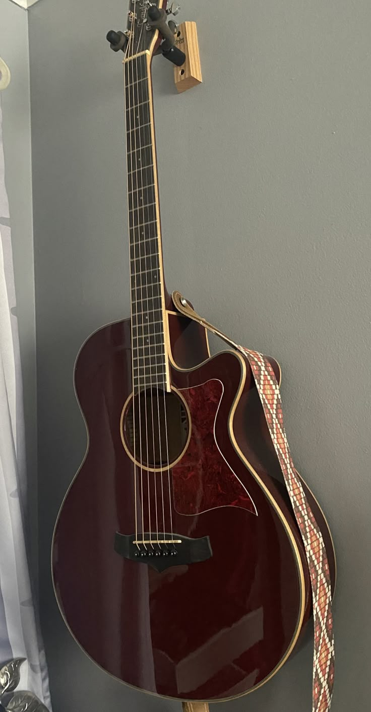 an acoustic guitar is hanging on the wall