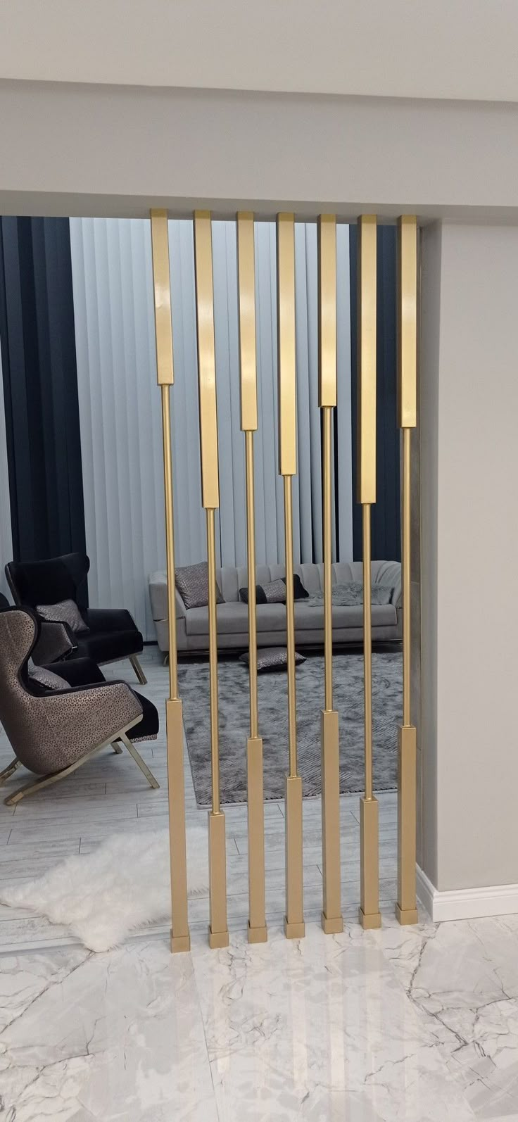 a room that has some chairs and a wall with gold bars on the walls in it