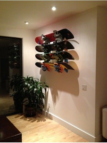 a wall mounted skateboard rack in the corner of a room with a potted plant