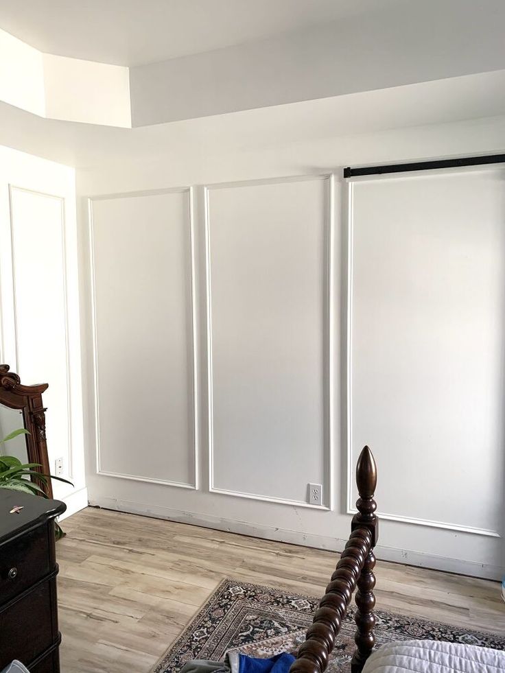 a bedroom with white closet doors and wooden bed frame in front of the sliding door