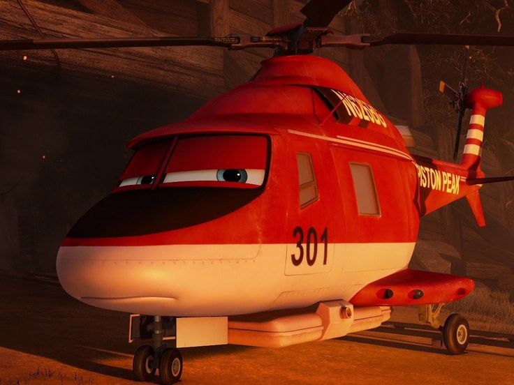 a red and white helicopter sitting on top of a dirt field