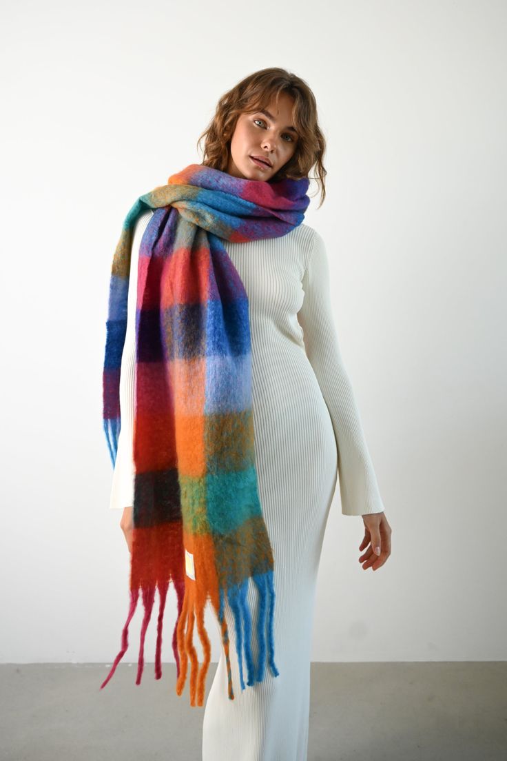 Made from recycled fabric and designed for layering in cold weather the Leah Scarf is our oversized, ultra soft blanket scarf with a colored plaid pattern and loose fringe ends. Wrap the Leah Scarf around once or twice for a luxe, blanketed look. Oversized, mid-weight scarf Multicolored plaid pattern Mixed watercolor hues of orange, green, red, and blue  Loose twisted fringe ends 97% recycled polyester, 3% recycled wool 11.6 inches x 90.5 inches  Accessories are final sale for sanitary purposes. Your order will ship from our warehouse in FL, USA! Bulky Scarf, Checkered Scarf, Oversized Blanket, Colorful Accessories, Colorful Scarf, Oversized Scarf, Blanket Scarf, Pattern Mixing, Soft Blankets