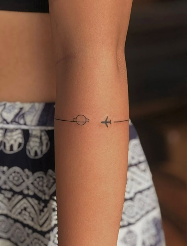 a woman's arm with an airplane tattoo on the left side of her arm