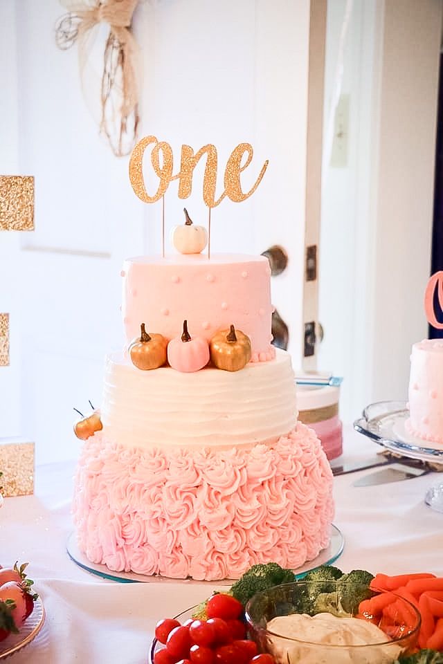 there is a cake that has been decorated with pink icing and gold letters on top