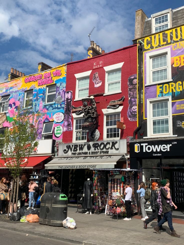 people walking on the sidewalk in front of colorful buildings