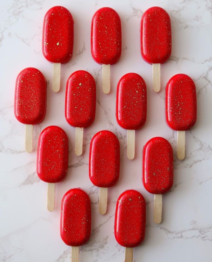 red popsicles are arranged on a marble surface