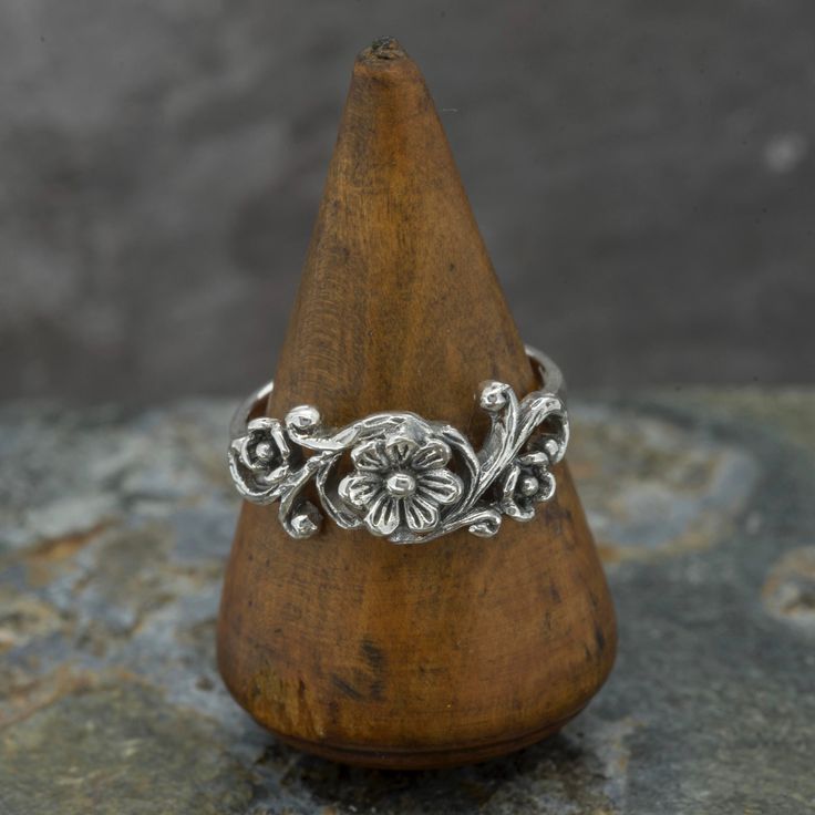 "An intricate silver ring with flower on a vine design. Oxidised sterling silver to highlight the details.  Wide range of sizes are available - chose when ordering - please see advice regarding sizing.  *Select ring size when ordering - US sizes are listed - l *See ring size chart if unsure  *Buyer responsible for postage if exchange in size required  *Comes Gift boxed  *Ships direct from Edinburgh, Scotland *Supports a small artisan business \"Happiness radiates like the fragrance from a flower and draws all good things towards you.\" Maharishi Mahesh Yogi We are very happy to exchange, however postal cost for exchange is the buyers responsibility. For accurate results we recommend going to a local jewellers to ask for a fitting. If you have bought this ring and would like to exchange it Oxidised Silver Ring, Maharishi Mahesh Yogi, Ring Size Chart, Oxidized Silver Rings, Boho Jewellery, Nature Ring, Vine Design, Edinburgh Scotland, Funky Jewelry