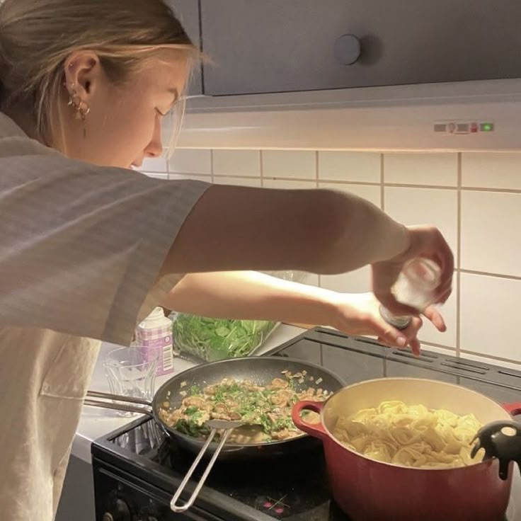 a woman cooking food in a pot on the stove