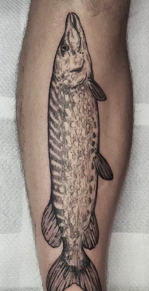 a fish tattoo on the leg of a man's leg, with an image of a