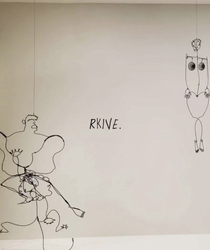 two drawings are hanging on the wall next to each other with words written above them