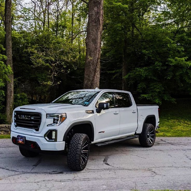 a white truck parked in front of some trees