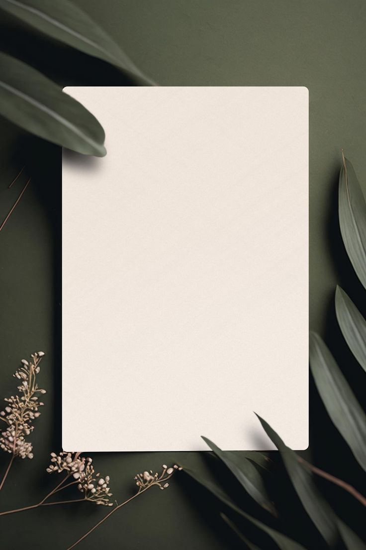 a sheet of paper sitting on top of a table next to some plants and leaves