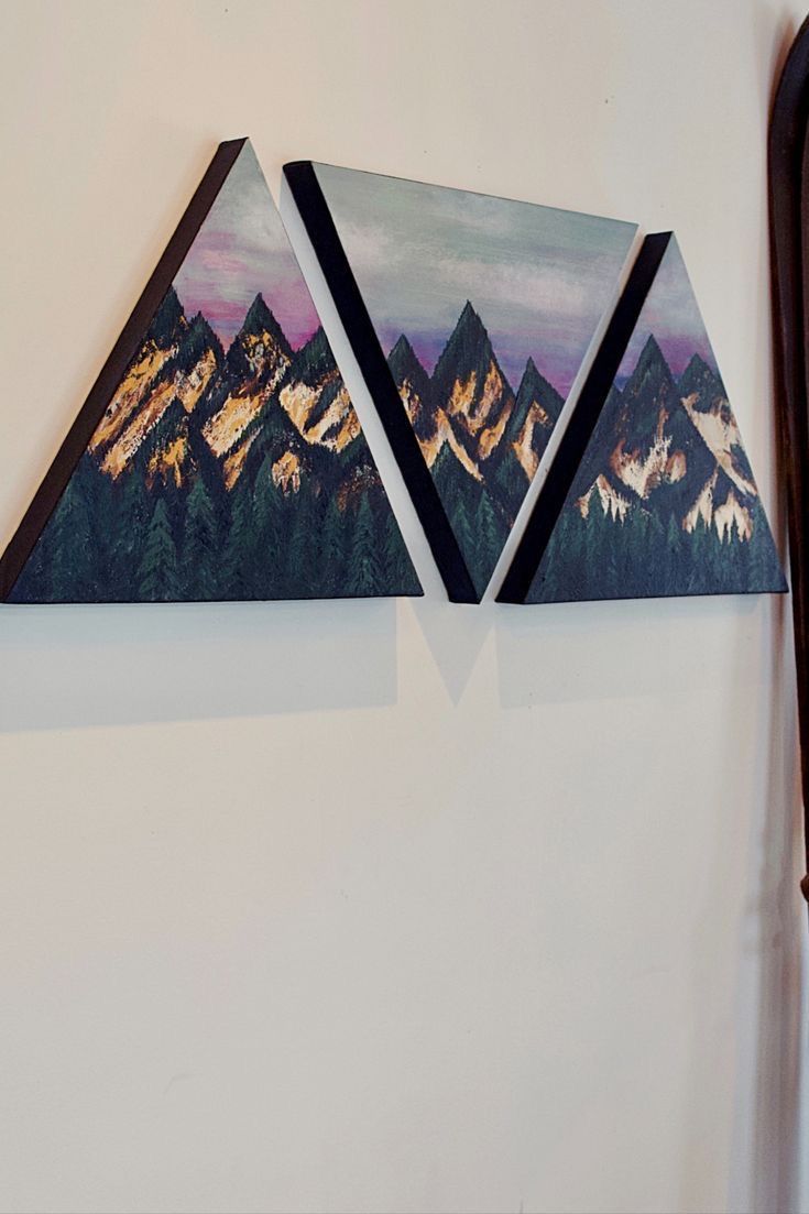 two triangle shaped paintings hanging on the wall