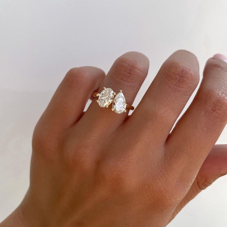 a woman's hand with a three stone ring on top of her left hand