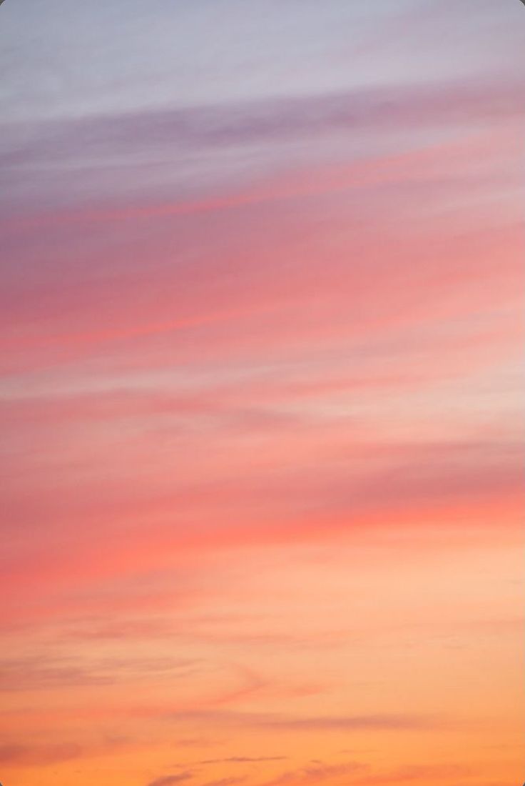 an airplane is flying in the sky at sunset or sunrise with pink and blue clouds