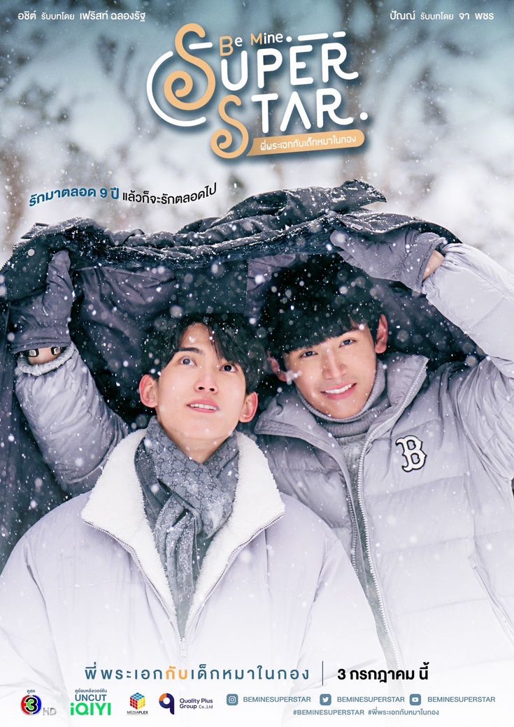 two young men standing in the snow under an umbrella