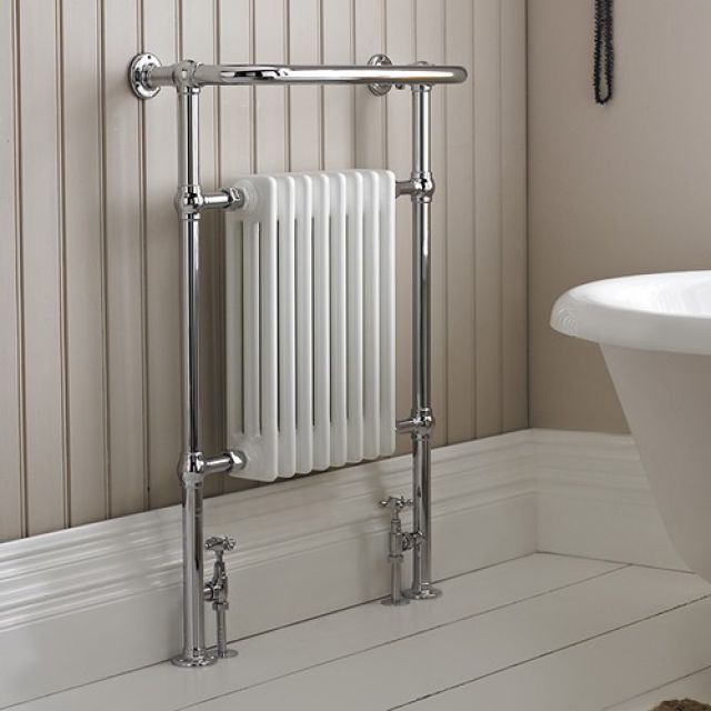 a white bath tub sitting next to a wall mounted radiator