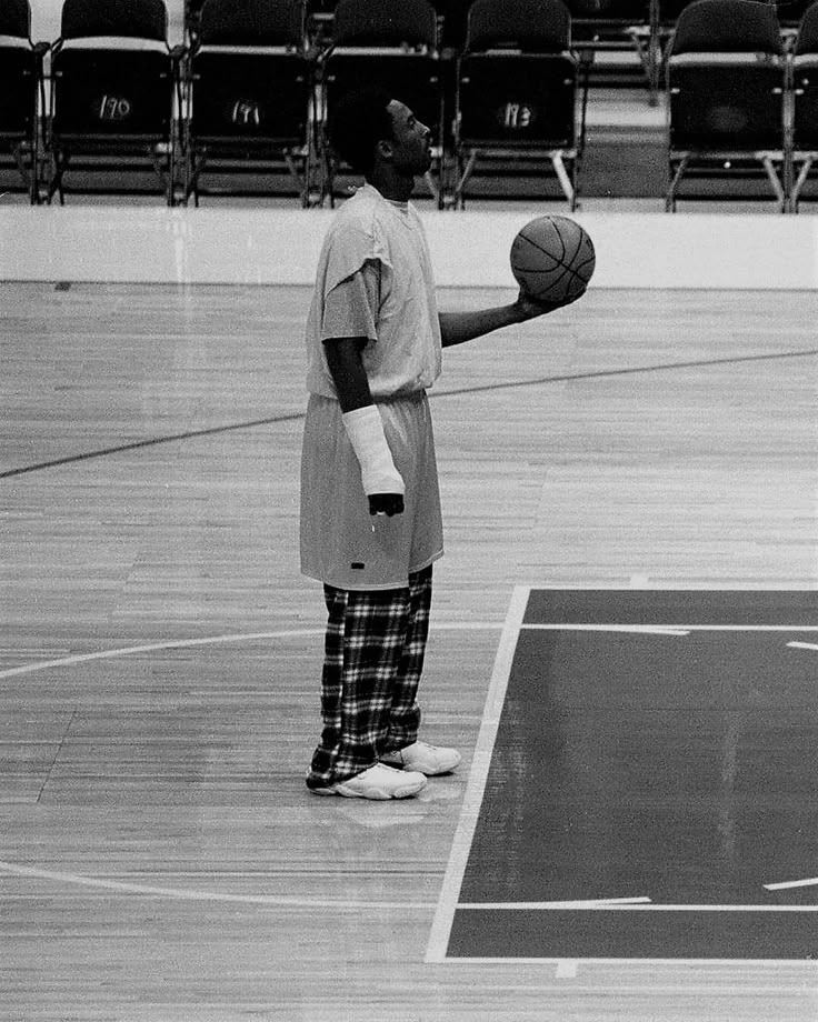 a man standing on top of a basketball court holding a ball