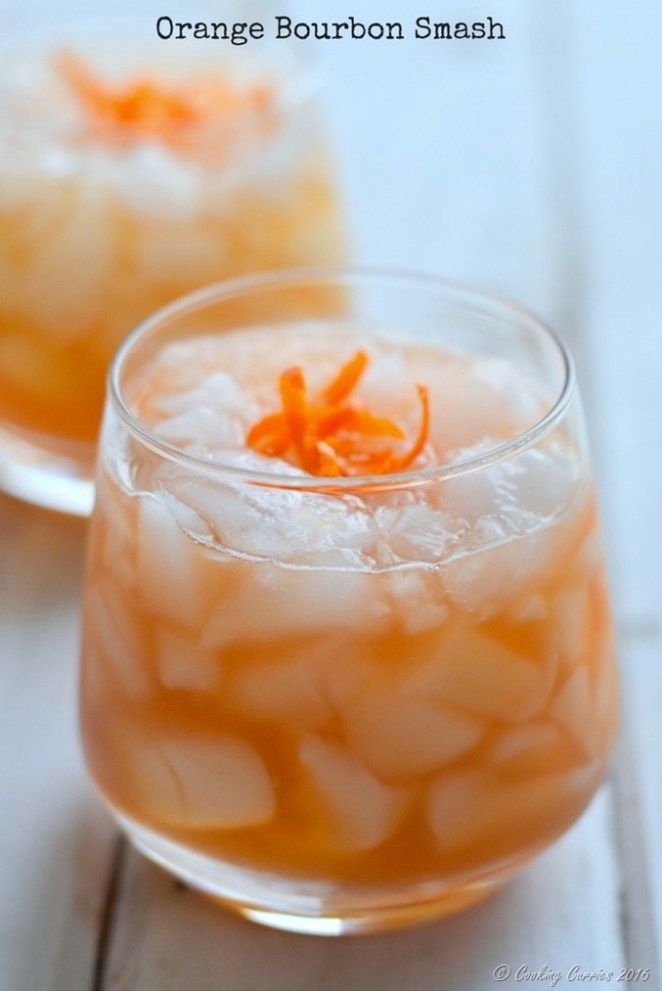 two glasses filled with orange bourbon smash