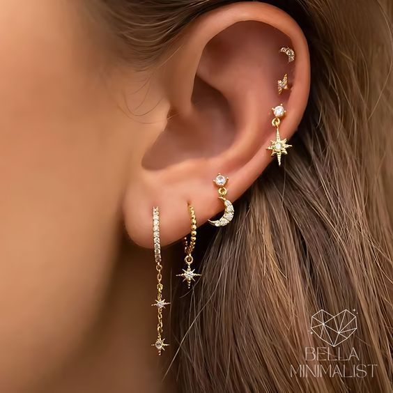 a woman's ear is shown with three stars and two danglings on it