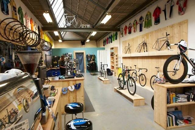 the inside of a bike shop with lots of bikes on shelves and bicycles hanging from the ceiling