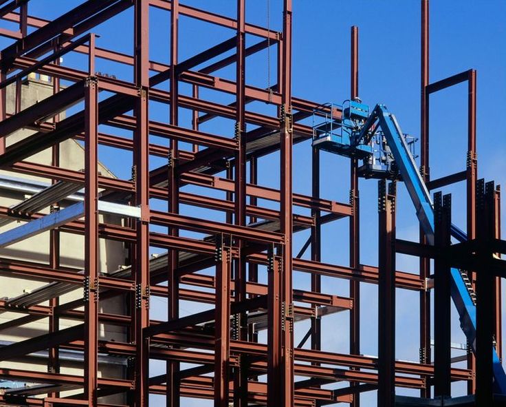 a crane is working on the side of a large building that's being constructed