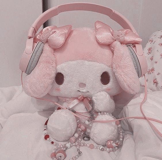 a pink stuffed animal with headphones on it's ears sitting next to a white teddy bear