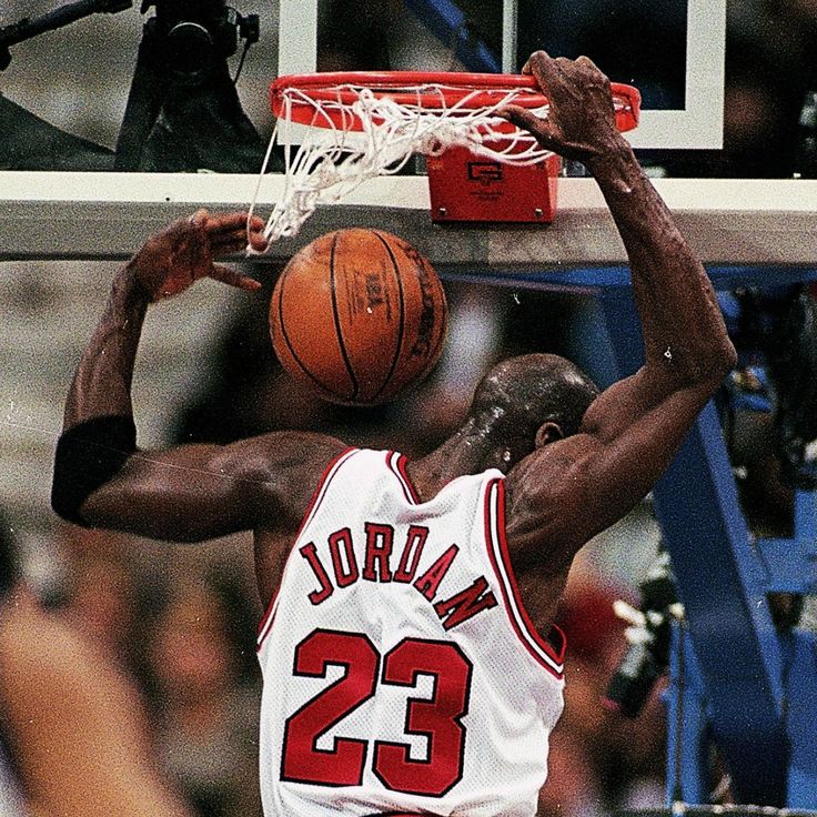 a basketball player dunks the ball in front of his opponent during a game against the bulls