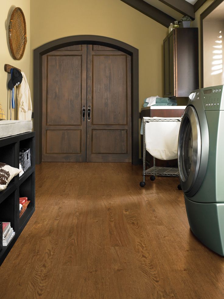 a washer and dryer in a room with wood flooring on the walls