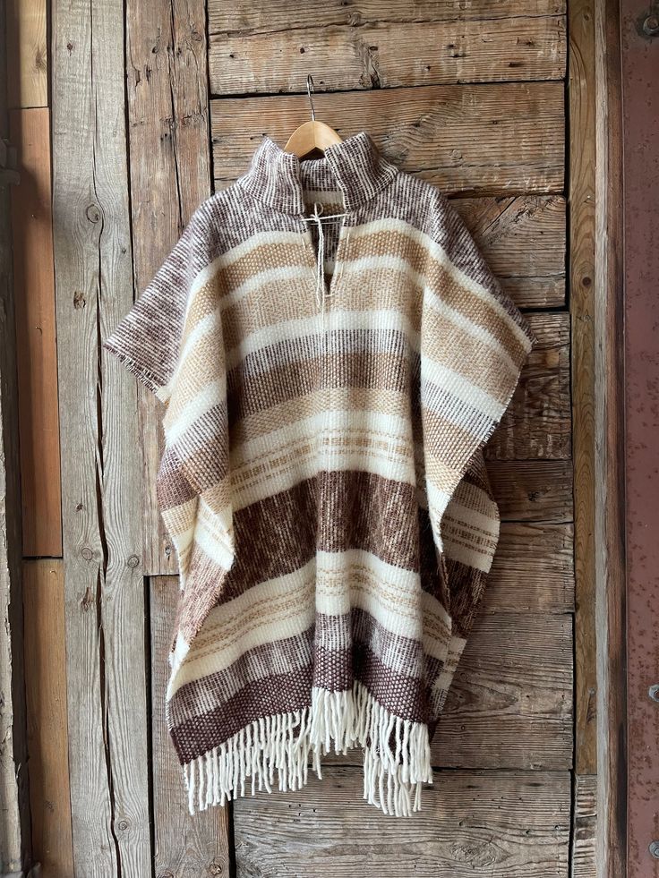 Brown wool poncho Alpaca/lambswool mix poncho Beige wool poncho very warm and breathable Ethno style Blanket poncho with fringes alpaca wool One size fits fashionably for most everyone, short or tall, big or small. This piece is versatile for both Men's & Women's outdoor fashion, and can be used insider in cooler winter weather to keep warm while reading on the couch. CARE: Hand-wash and hang to dry, light iron if needed, or dry clean. MEASURES: Length at the front of the neckline to the bottom Bohemian Wool Poncho In Cape Style, Bohemian Wool Poncho Cape, Cozy Brown Alpaca Poncho, Handwoven Brown Poncho For Winter, Handwoven Wool Poncho For Fall, Brown One Size Poncho With Fringe, One Size Brown Fringe Poncho, Brown Fringe One Size Poncho, Traditional Beige Poncho For Winter