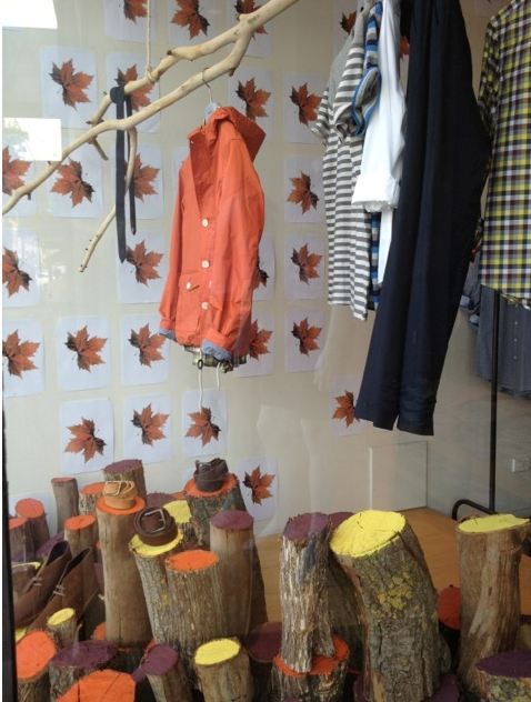 clothes are hanging on the wall next to logs and tree stumps in front of them